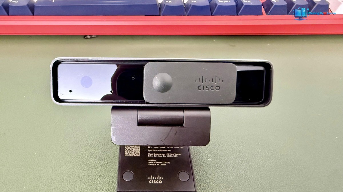 Mặt trước webcam Cisco với nắp che ống kính và chân kẹp mở
