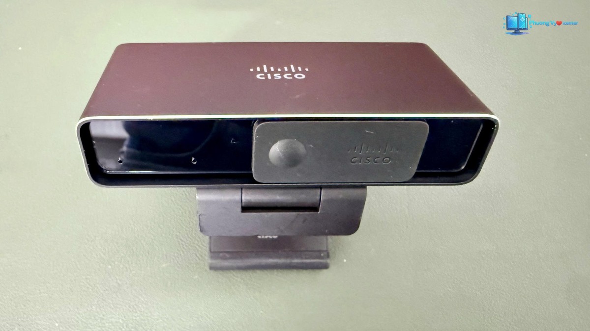 Webcam Cisco nhìn chếch từ trên, thấy logo Cisco ở mặt trên và chân kẹp