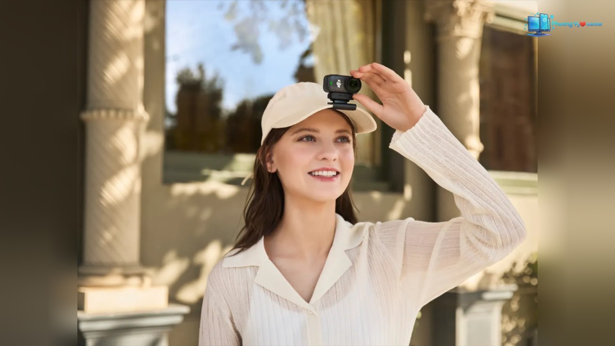DJI Osmo Nano gắn trên vành mũ, người dùng đưa tay điều chỉnh camera