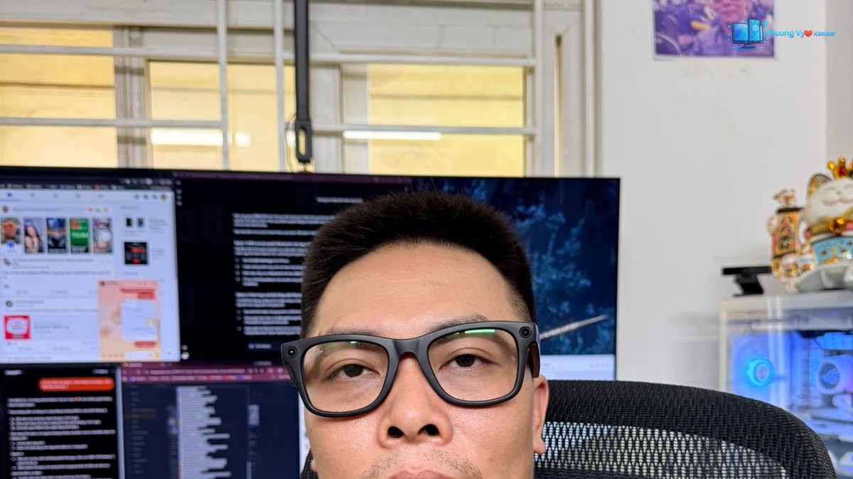 Người đeo kính INMO GO3 gọng đen ngồi tại bàn làm việc có nhiều màn hình