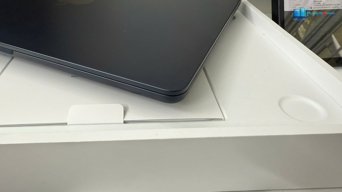 Cận cảnh góc bo tròn và mép Apple MacBook Air M3 đóng trên khay hộp