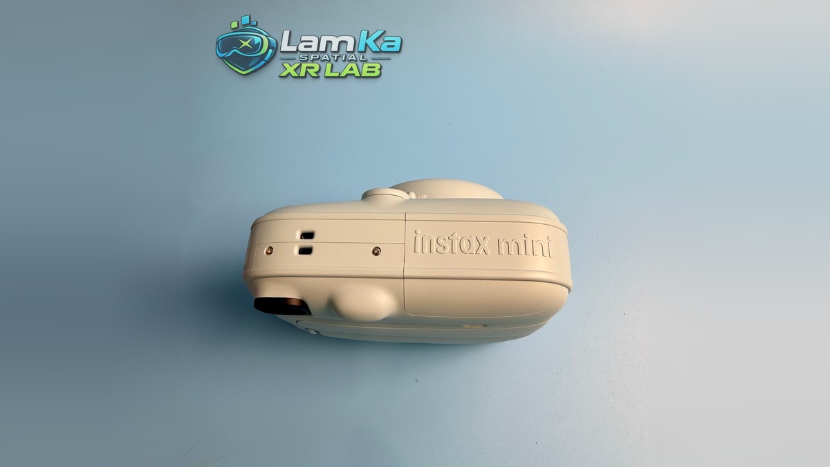 Cạnh dưới Fujifilm Instax Mini 13 với chữ Instax mini dập nổi, các lỗ nhỏ và vít