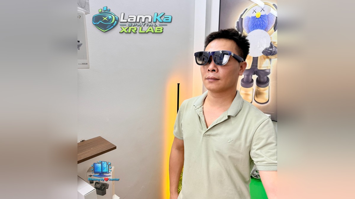 Người đàn ông mặc áo xanh nhạt đang đeo kính XREAL 1S tại cửa hàng